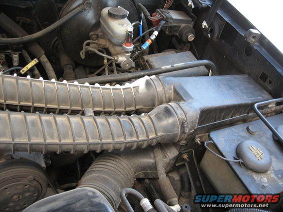 Engine bay showing air intake hoses and brake fluid reservoir