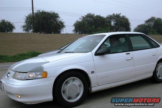 1991 Ford Taurus sedan driving on a highway, front passenger side view
