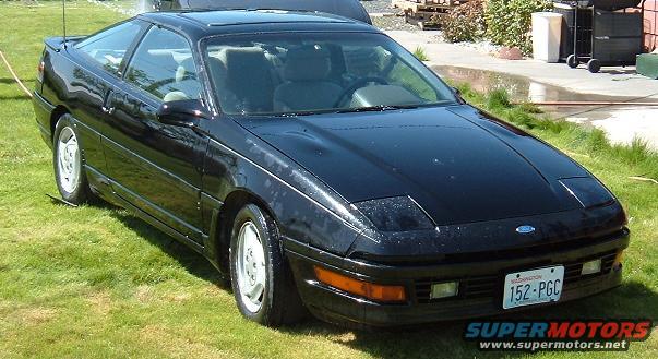 Black 1991 Ford Probe GT Turbo coupe with pop-up headlights parked on grass