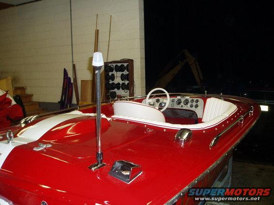 Red and white boat interior with white steering wheel and dashboard gauges