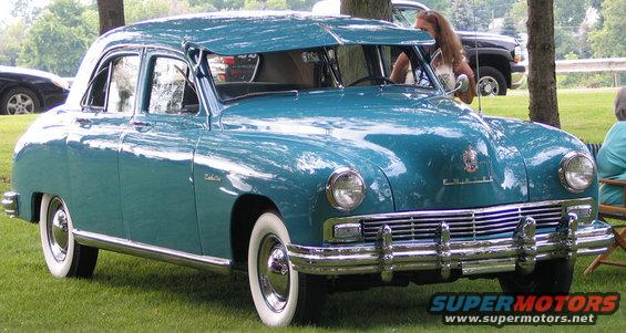 Teal sedan with whitewall tires and chrome grille