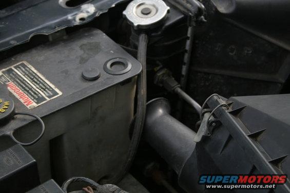 Close-up of engine bay parts including a Motorcraft coolant reservoir and air intake