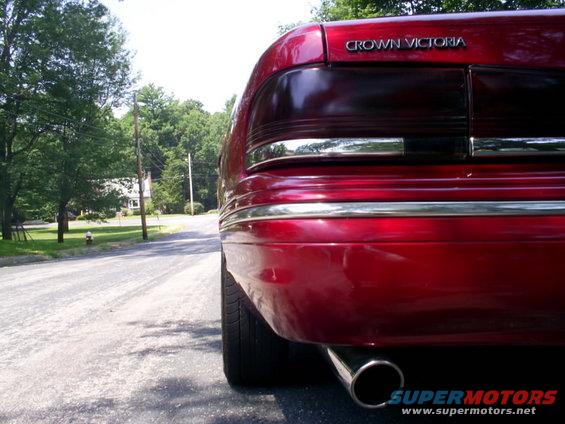 Red 1995 Ford Crown Victoria rear, chrome trim, exhaust pipe, on a paved road