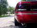 1995 Ford Crown Victoria - The rear of a red 1995 Ford Crown Victoria is visible with chrome accents and an exhaust pipe.