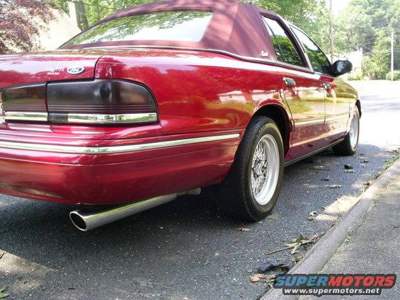 Red sedan's rear quarter panel and vinyl top. 1995 Ford Crown Victoria