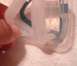 1991 Yugo Cabrio - A hand holds a clear plastic medical device with blue tubing, suggesting a close-up view of a part.