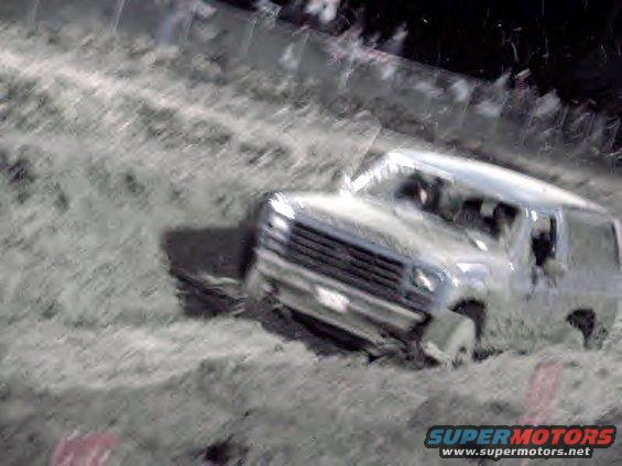 Silver 1983 Ford Bronco stuck in mud, front 3/4 view