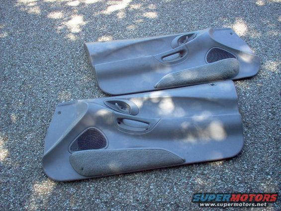 Pair of gray car door panels with speaker grilles and armrests