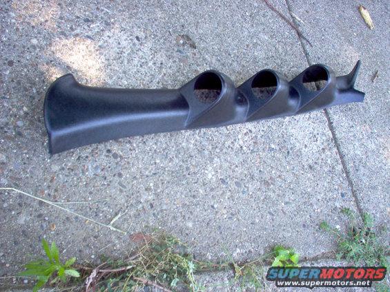 Black plastic triple gauge pod for interior mounting, resting on concrete