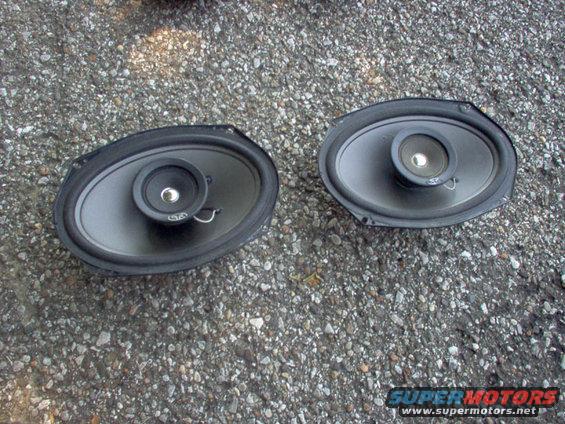 two oval car speakers on gravel