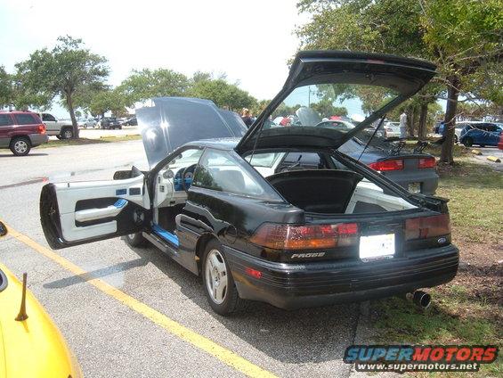 Black 1989 Ford Probe with doors and hood open, rear view