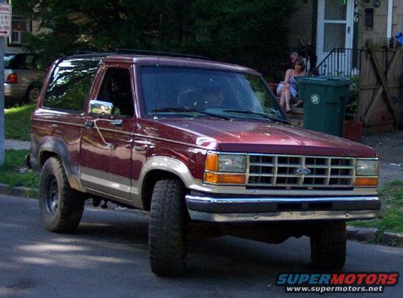 Maroon Ford Bronco II with silver trim, 3/4 front view, lifted suspension