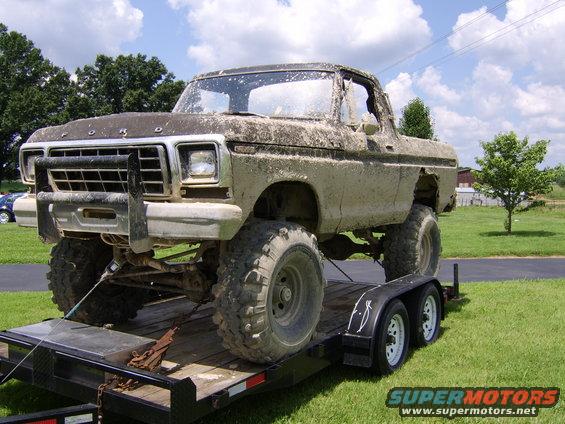 Mud-covered 1978 Ford Bronco on a trailer, front bull bar, lifted suspension, large tires