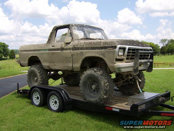 Mud-covered 1978 Ford Bronco on trailer, front 3/4 view