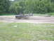 1978 Ford Bronco - A black pickup truck navigates a muddy track while an ATV follows behind in the distance.