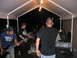 1986 Ford Mustang - A band performs live music under a tent at an outdoor event.