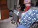 1986 Ford Mustang - A man wearing a fedora and a t-shirt with a graphic print kneels on the floor in a room.