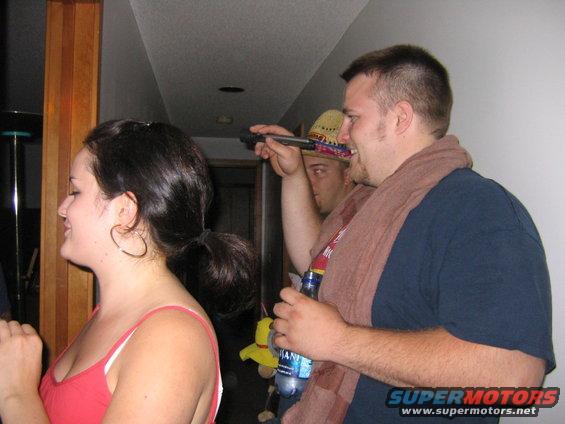 People celebrating at a party, one holding a bottle
