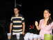 1986 Ford Mustang - Two people stand near a table set up for a game of beer pong at night.