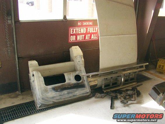 Car grille and door panel parts on a floor