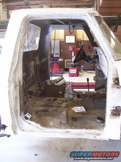 Interior of white pickup truck cab, stripped down for restoration