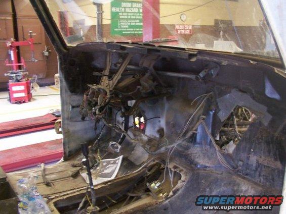 Disassembled vehicle dashboard with exposed wiring and empty space