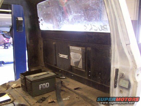 Interior view of a vehicle's rear, showing a green toolbox labeled 'FOD' and a metal panel on the wall