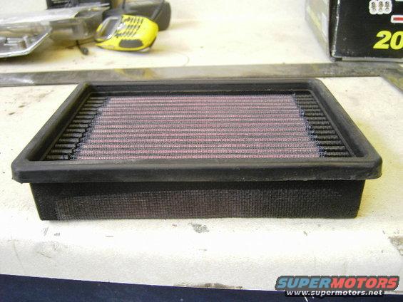 Black air filter with pinkish-red filter media