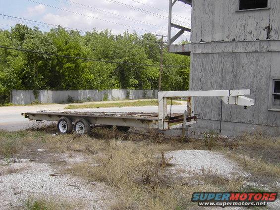 flatbed trailer with gooseneck hitch parked next to a building