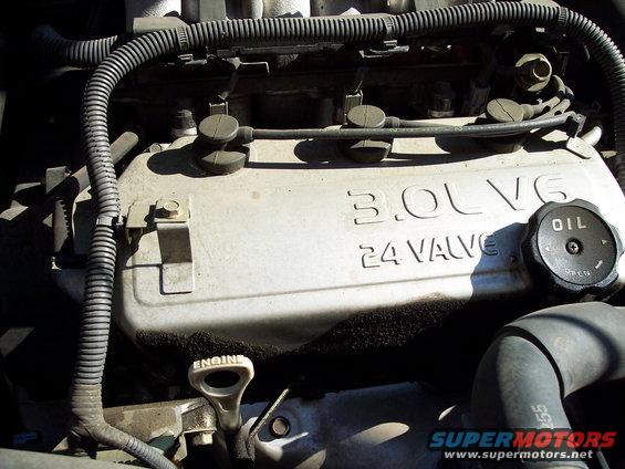 Close-up of a 3.0L V6 24-valve engine cover with an oil cap and engine dipstick visible