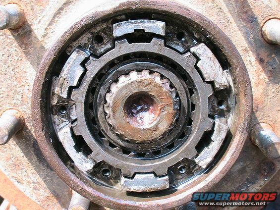 close-up of a rusty manual locking hub assembly with visible gears and bolts
