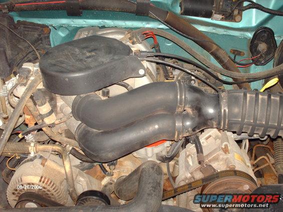 Engine bay with air intake hoses and alternator. Date stamp 06/26/2006