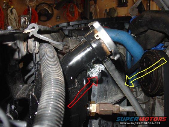 Engine bay with hoses, a belt, and pulleys. Red arrows point to a clamp and a hose connection. Yellow arrow points to a belt