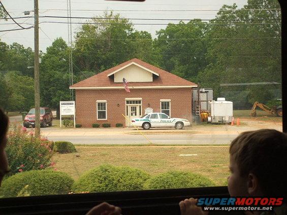 White police car parked in front of brick building, side view