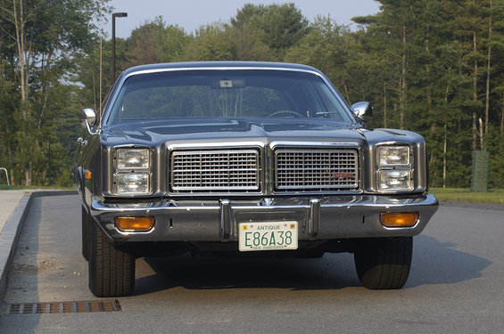 Front view of a 1977 Dodge sedan with a chrome grille and quad headlights. License plate reads E86A38