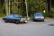 1978 Dodge Monaco - A dark gray sedan is parked next to another car in a lot with trees in the background.