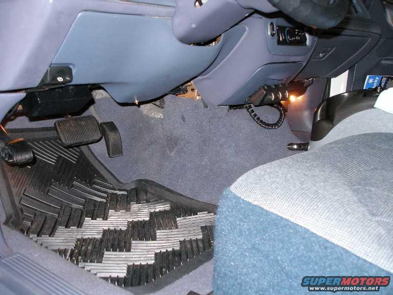 Driver's side footwell with rubber floor mats, brake and accelerator pedals, and part of the dashboard