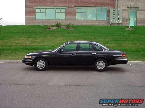 Black 1998 Ford Crown Victoria parked outside a brick building