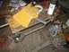 1969 Ford Mustang - A workbench scene yellow work gloves, tape, and a can of spray paint, with various tools and materials scattered around.
