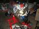 1969 Ford Mustang - A V8 engine is mounted on a red engine stand in a cluttered garage setting.