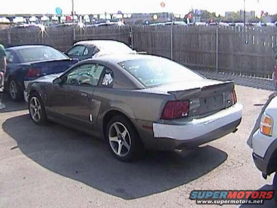 Rear view of a gray 1999 Ford Mustang with a white bumper
