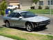 1993 Ford Probe - This silver coupe is missing its front bumper and appears to be undergoing repairs or has been damaged. A white pickup truck is visible in…