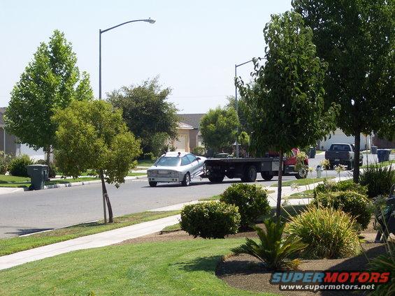 Silver 1993 Ford Probe being towed, rear view