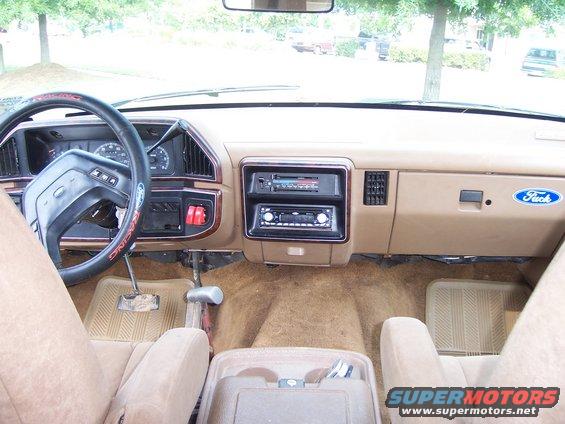 Tan interior of a 1990 Ford Bronco, showing dashboard, steering wheel, and seats