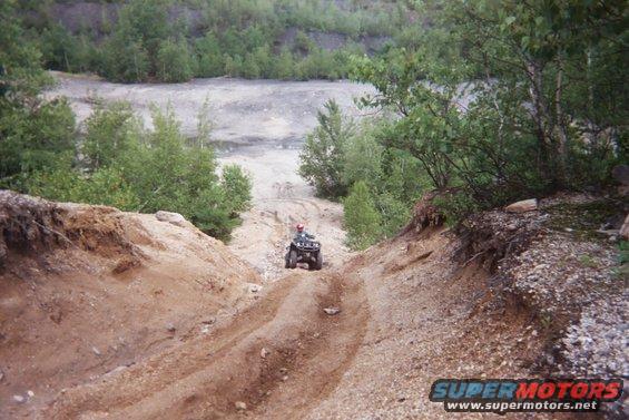 Four-wheeler descending a dirt path in a quarry