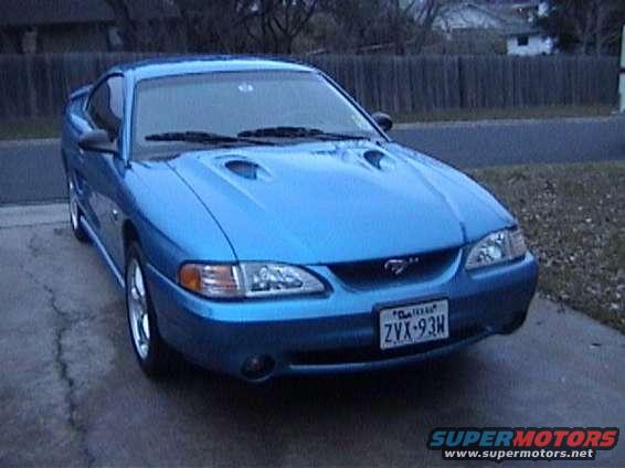 Blue Ford Mustang with dual hood scoops and a license plate reading ZVX-93H