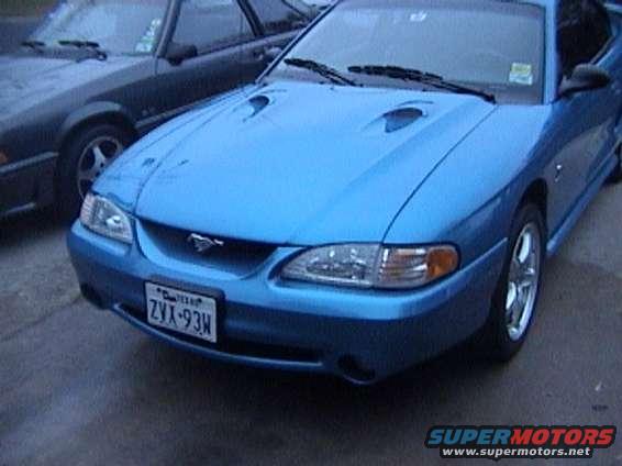 Blue Ford Mustang parked next to a dark car. License plate ZVX-93H