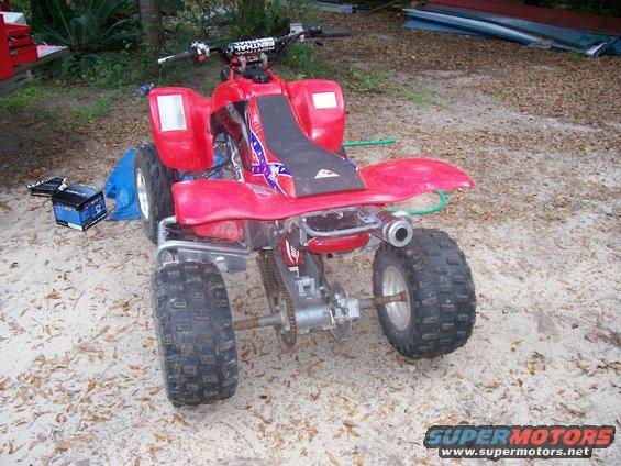 Red ATV with a Confederate flag seat cover, parked on sand