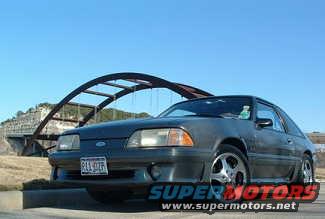 Dark gray 1987-1993 Ford Mustang hatchback with aftermarket wheels parked outdoors