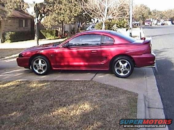 red coupe parked on curb, side view